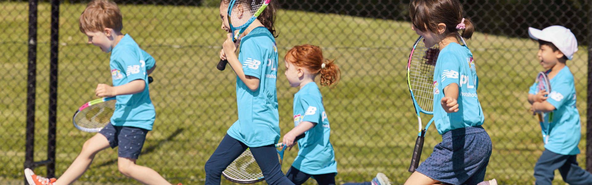 Happy Tennis Hot Shots kids running on tennis court