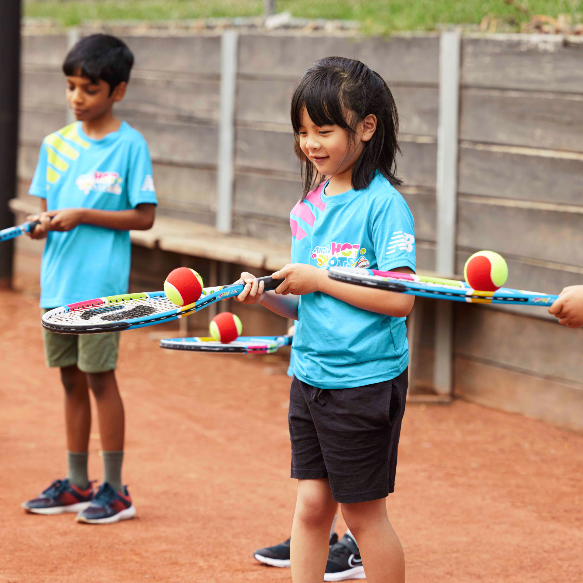Girl balancing ball on tennis racquet
