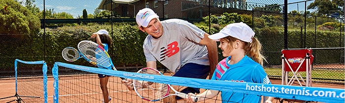 Photo of a kid being coaching during ANZ Tennis Hot Shots